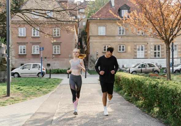 A couple jogging together in an urban park, enjoying outdoor exercise.